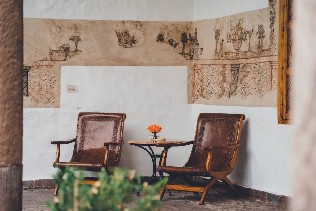 two brown armchairs with orange flower on table