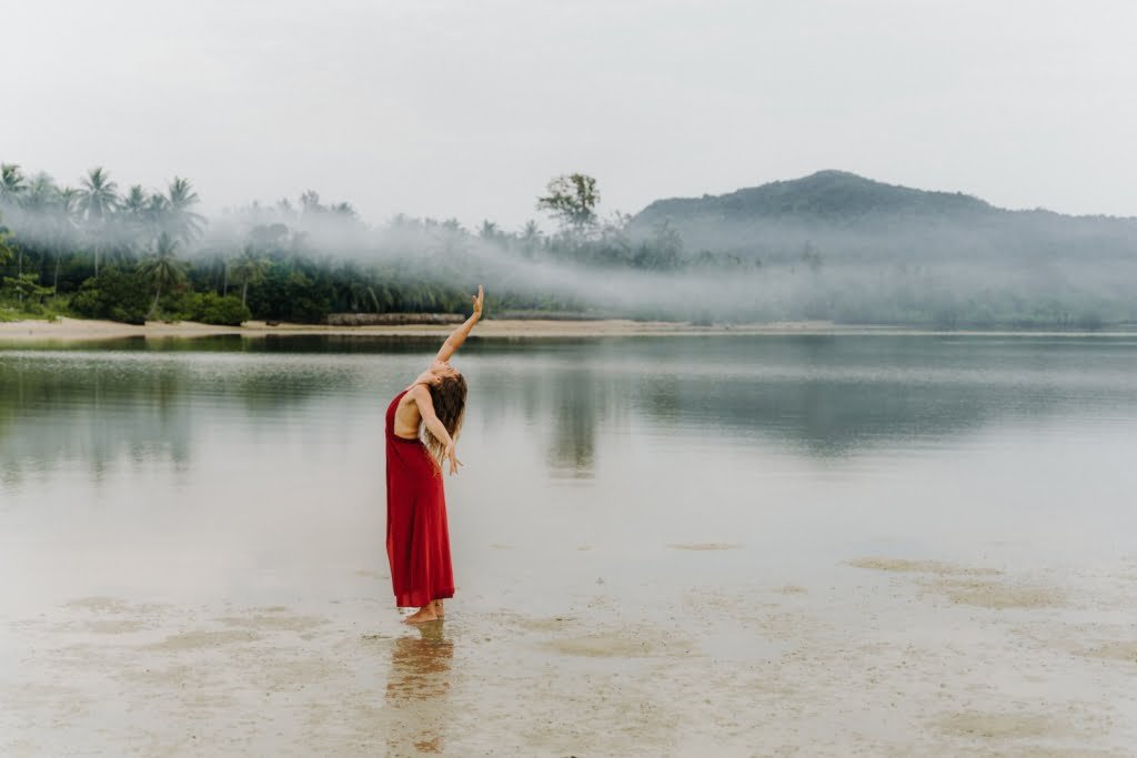 a woman in a red dress standing in the water