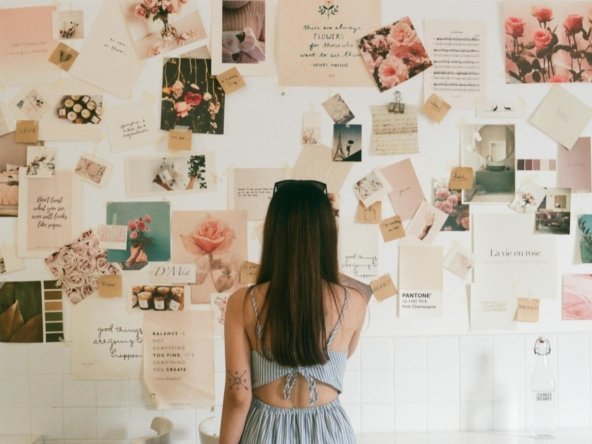 Woman Looking at Wall with Images and Cards