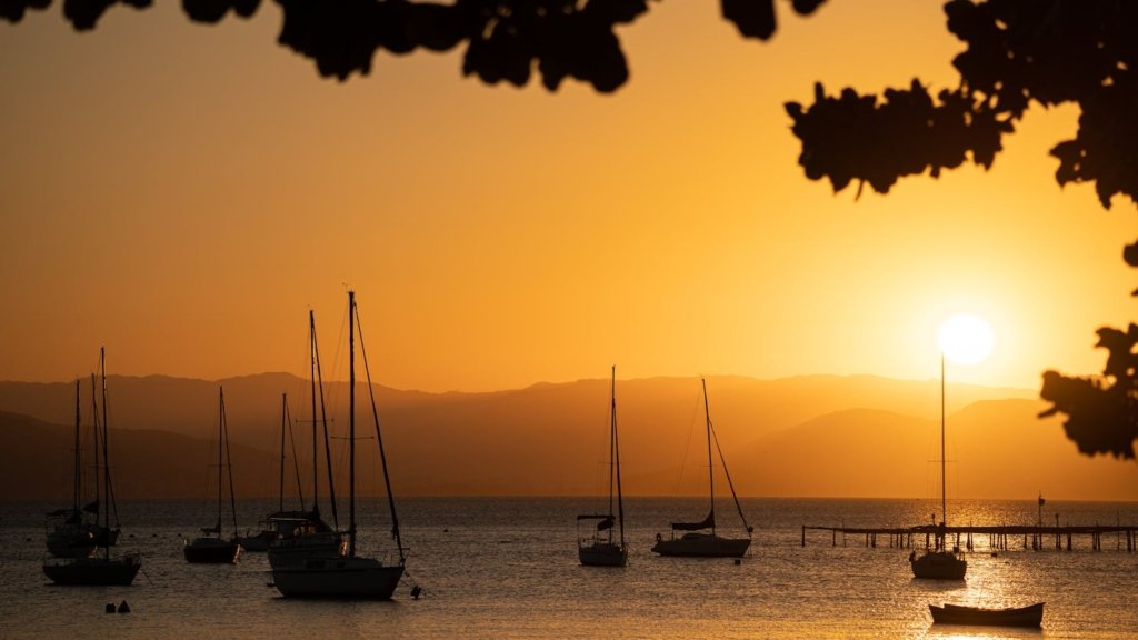 Tranquil sunset scene with sailing yachts on a bay in Florianópolis, Brazil.